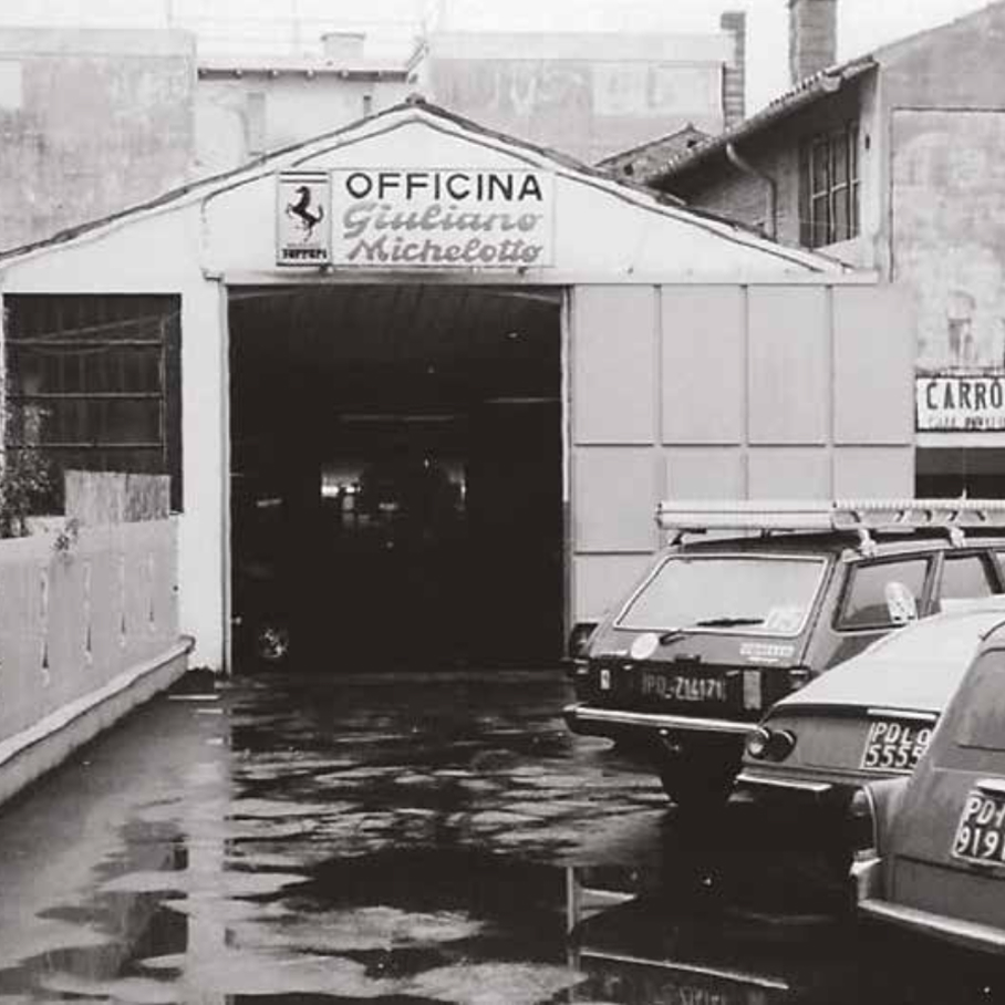 Esterno dell'Officina Giuliano Michelotto a Padova con insegna e logo Ferrari, foto in bianco e nero
